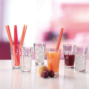 Longdrinkgläser mit Getränken, Strohhalmen und Früchten auf Tisch