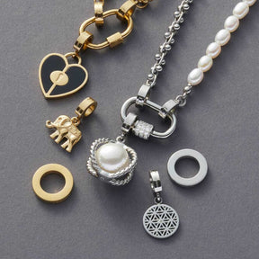 Edelstahlring klein flach silber mit Schmuckzubehör und Ketten auf grauem Untergrund