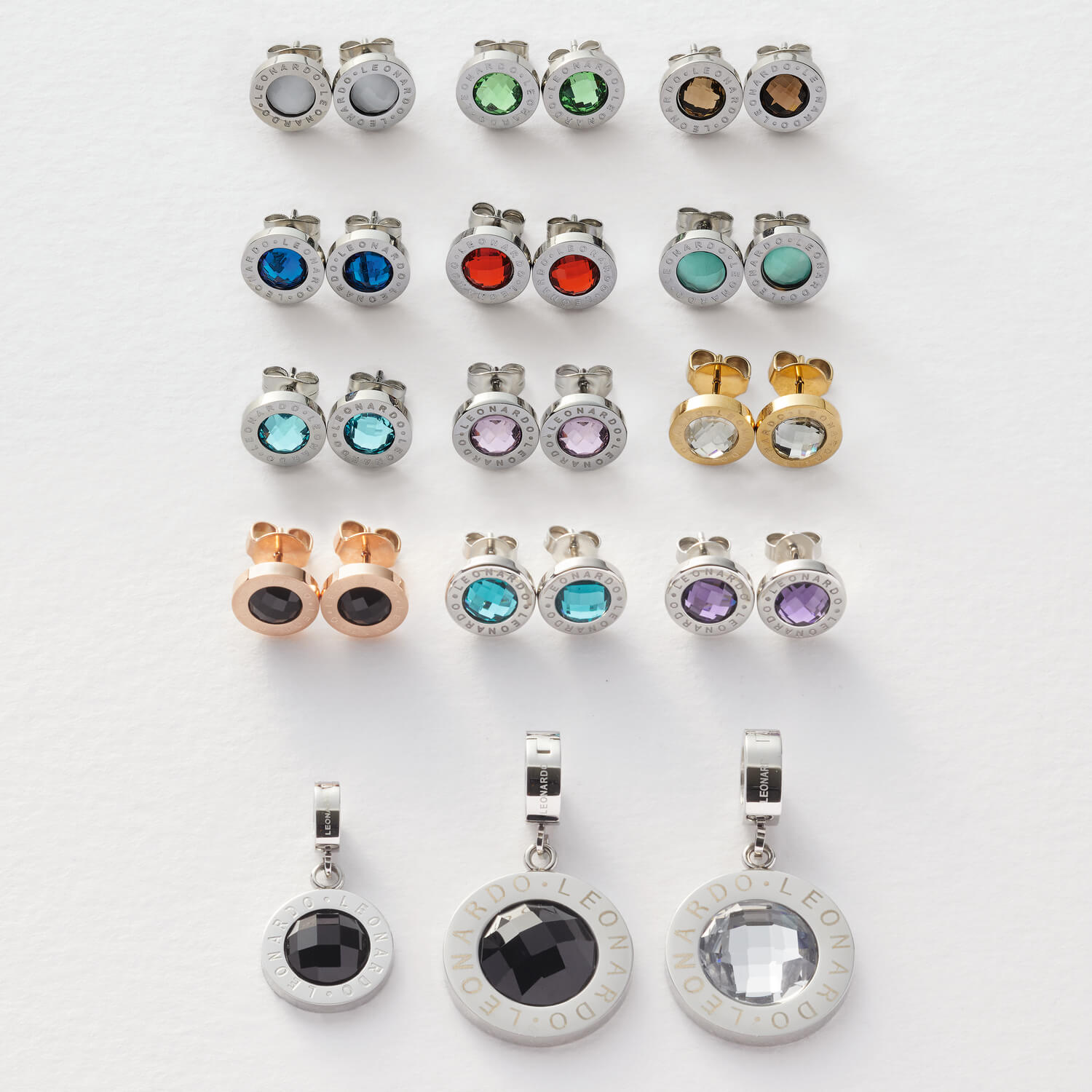 Schmuck-Kollektion mit verschiedenfarbigen Ohrringen und Anhaengern in Draufsicht