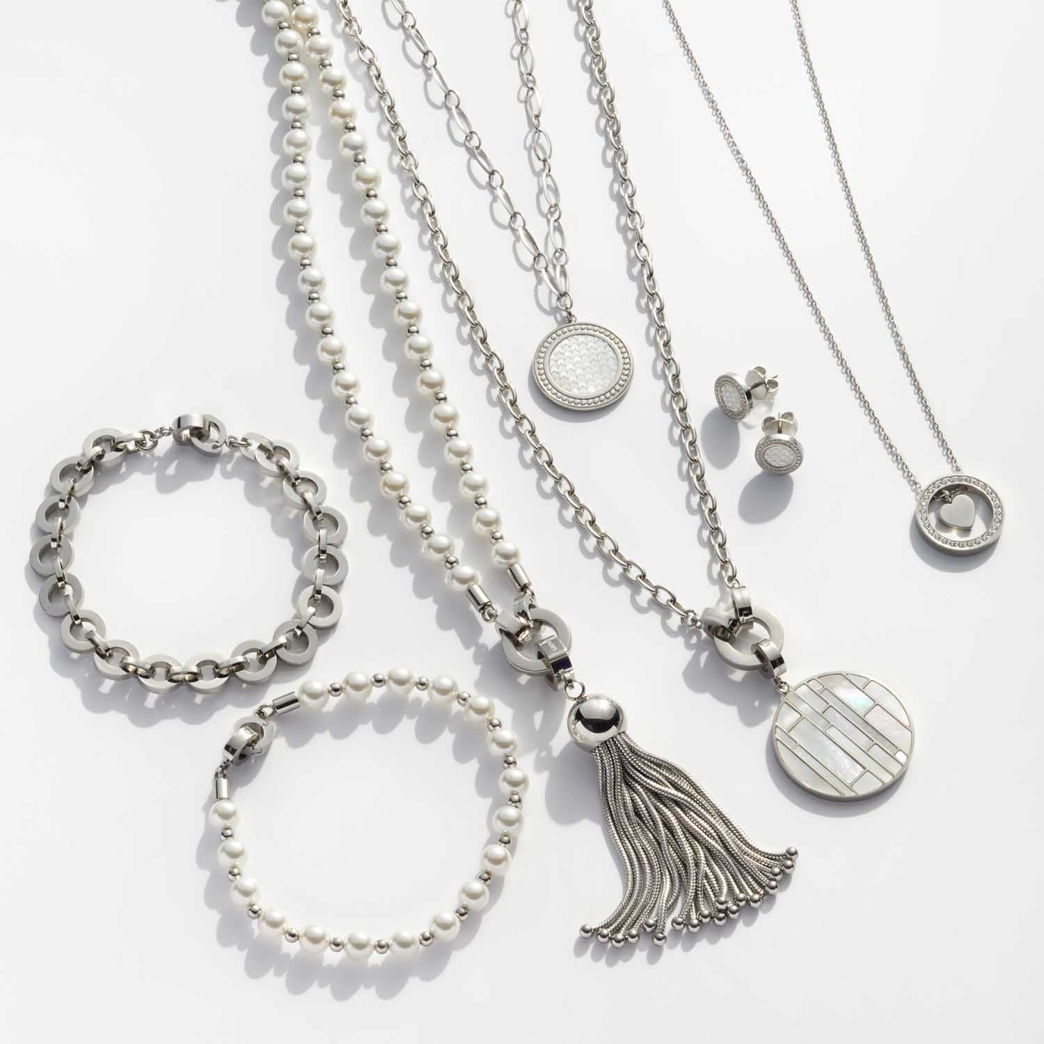 Silberschmuck-Kollektion mit Armbändern, Ketten und Ohrringen auf weißem Hintergrund