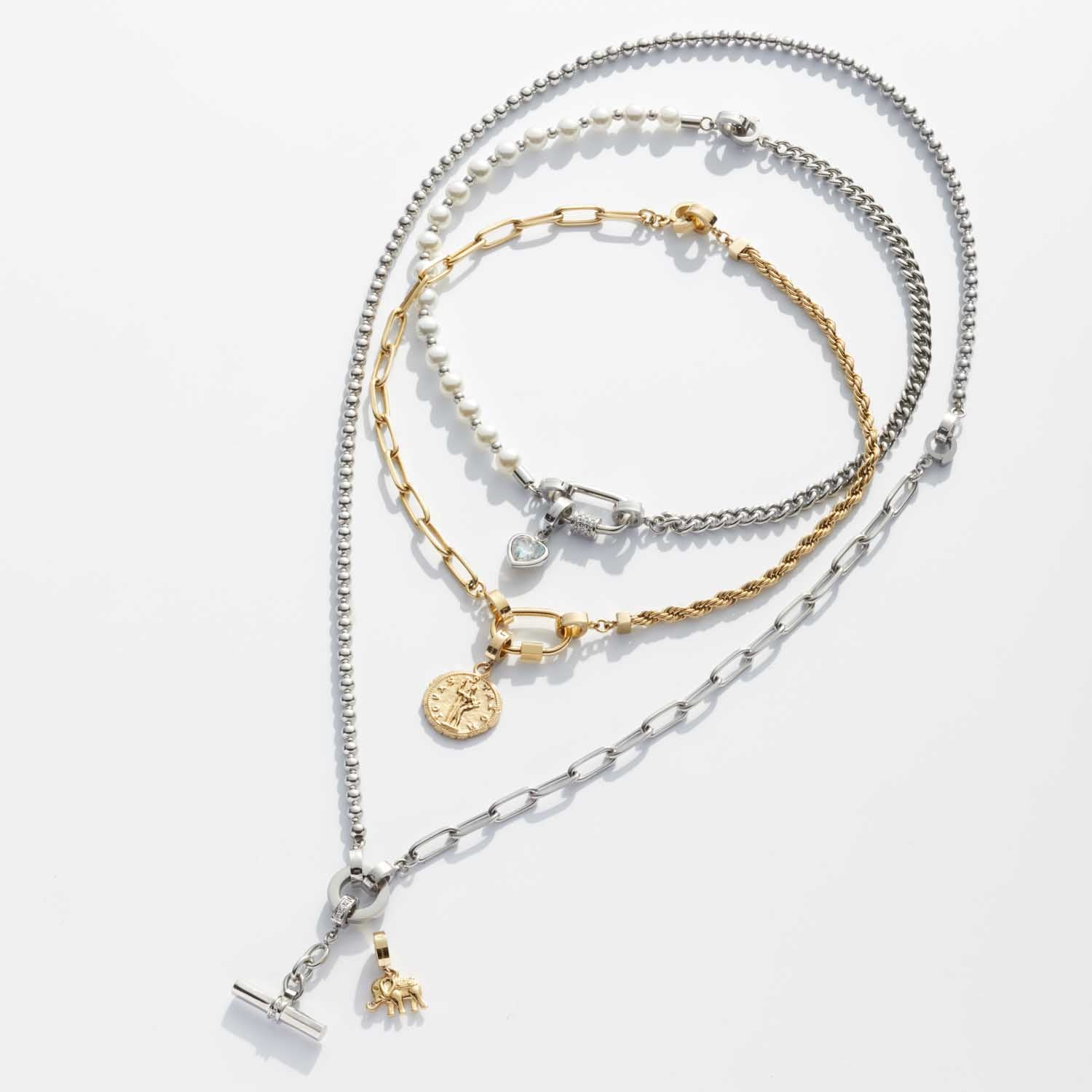 Mehrere silberfarbene und goldfarbene Armbänder mit verschiedenen Kettenglieder-Designs und austauschbaren Anhängern