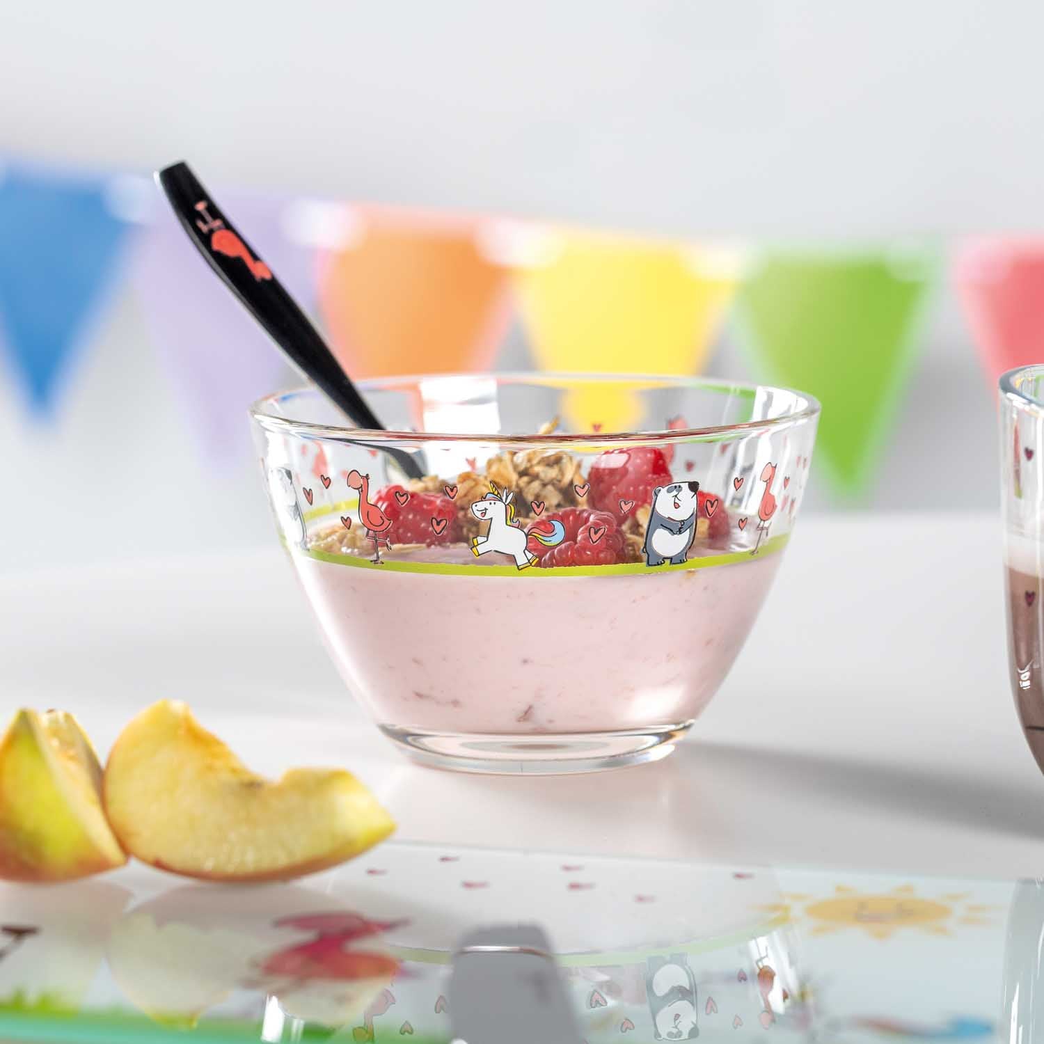 Schale BAMBINI mit Joghurt, Löffel und Apfelscheiben auf Tisch