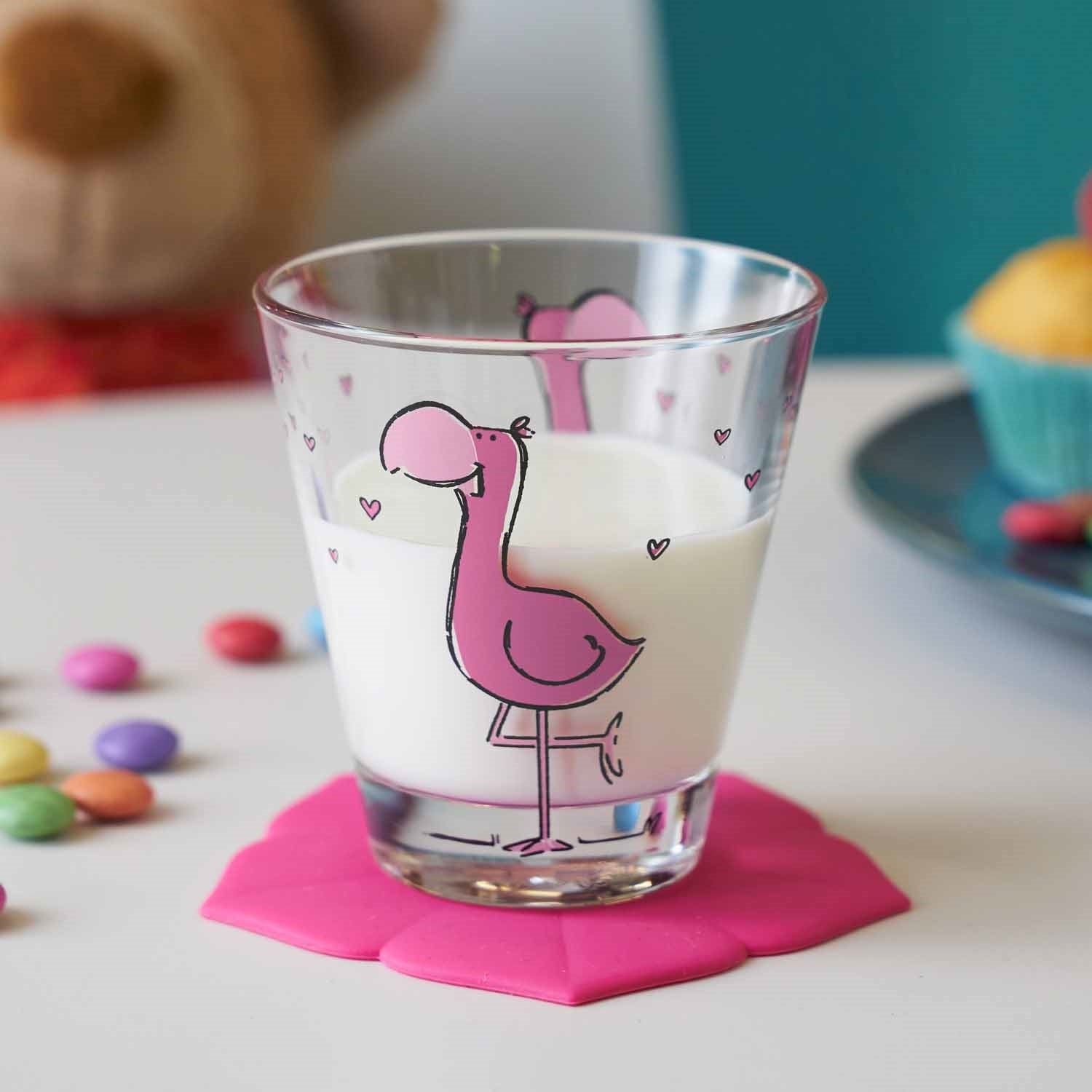 Trinkglas BAMBINI mit Flamingo-Motiv, gefüllt mit Milch, auf pinkem Untersetzer