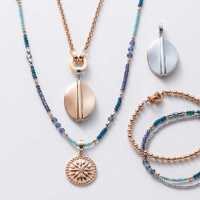 Schmuckkollektion mit Armbändern, Ketten und Anhängern in Blau- und Roségoldtönen