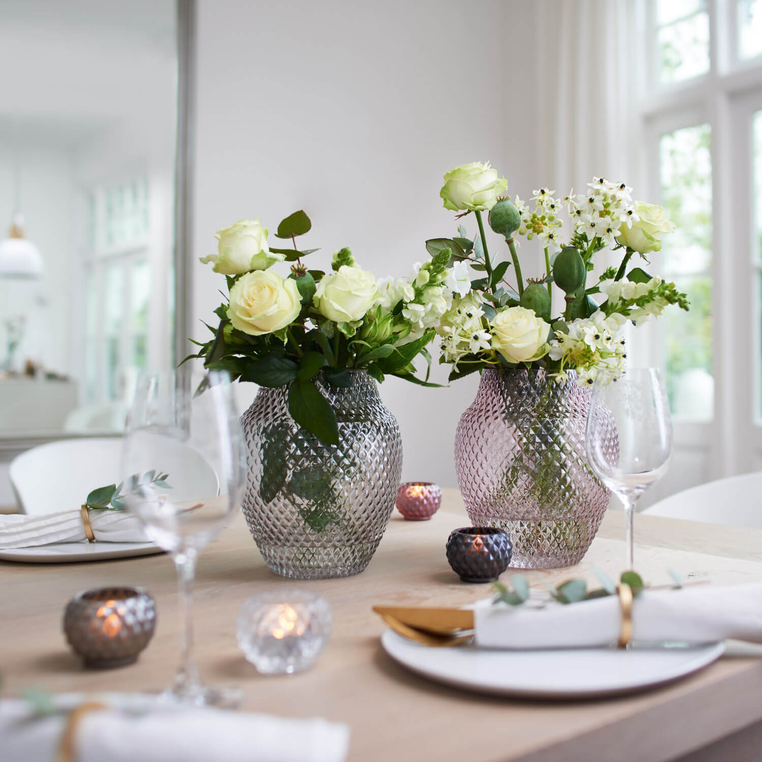 Vase POESIA mit weißen Rosen und Schleierkraut auf gedecktem Tisch