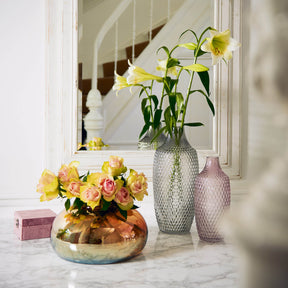 Vase POESIA mit gelben Narzissen auf Marmortisch in Wohnraum