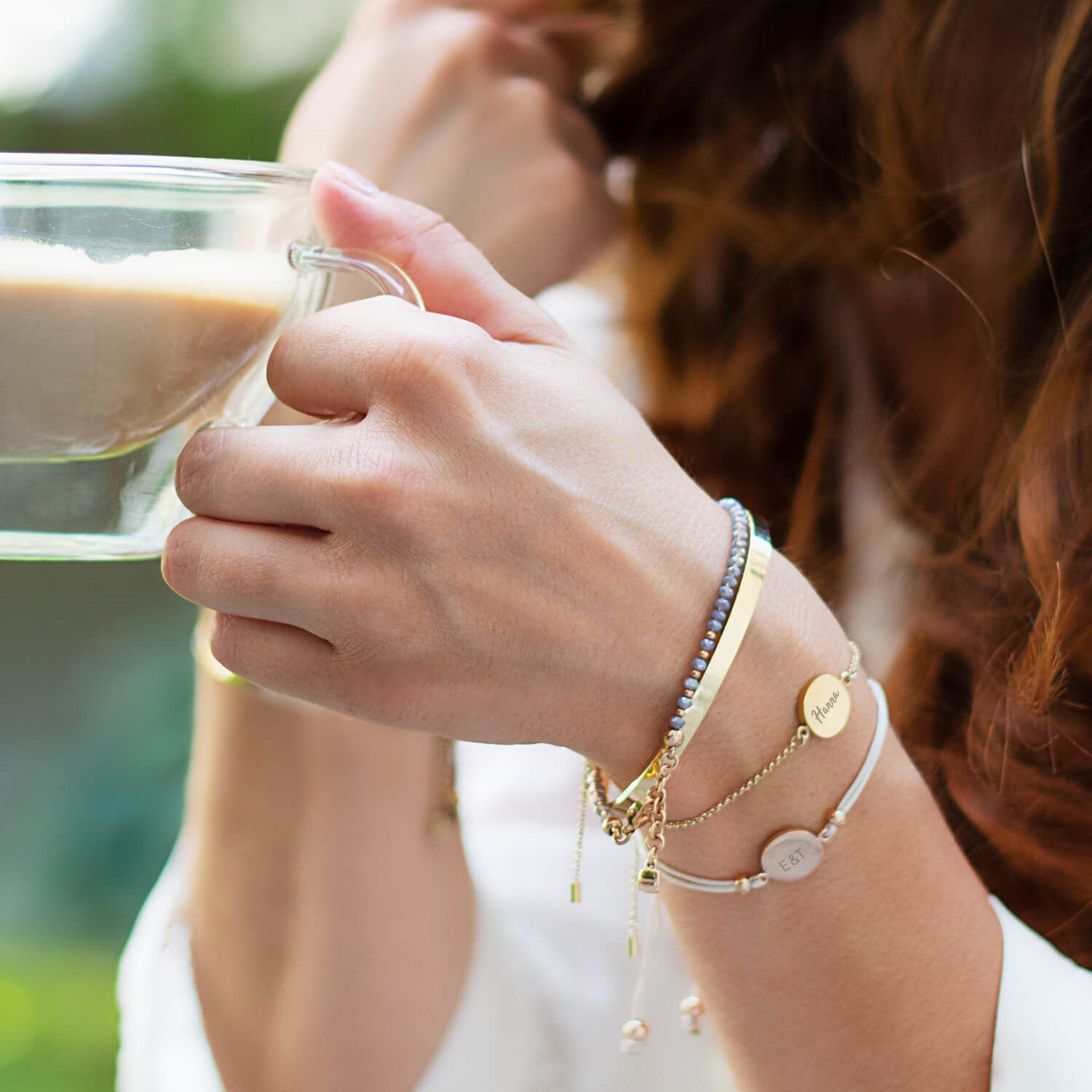 Frau mit Armband MARLA gold beim Trinken aus Glas im Freien