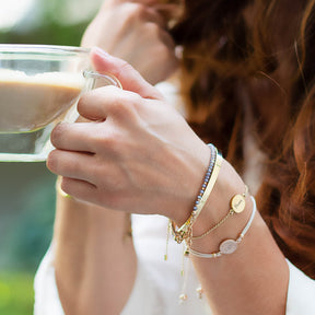 Frau mit Armband MARLA gold beim Trinken aus Glas im Freien