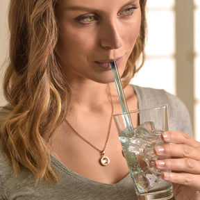 Frau trinkt aus Glas mit farbigem Glastrinkhalm CIAO
