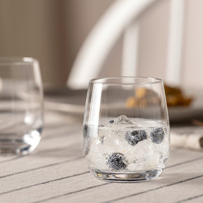 Trinkglas TIVOLI mit Eiswürfeln auf sonniger Terrasse, weitere Gläser im Hintergrund