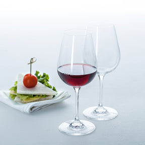 Rotweinglas TIVOLI mit Rotwein gefüllt, leeres Glas daneben, Appetizer mit Tomate im Hintergrund