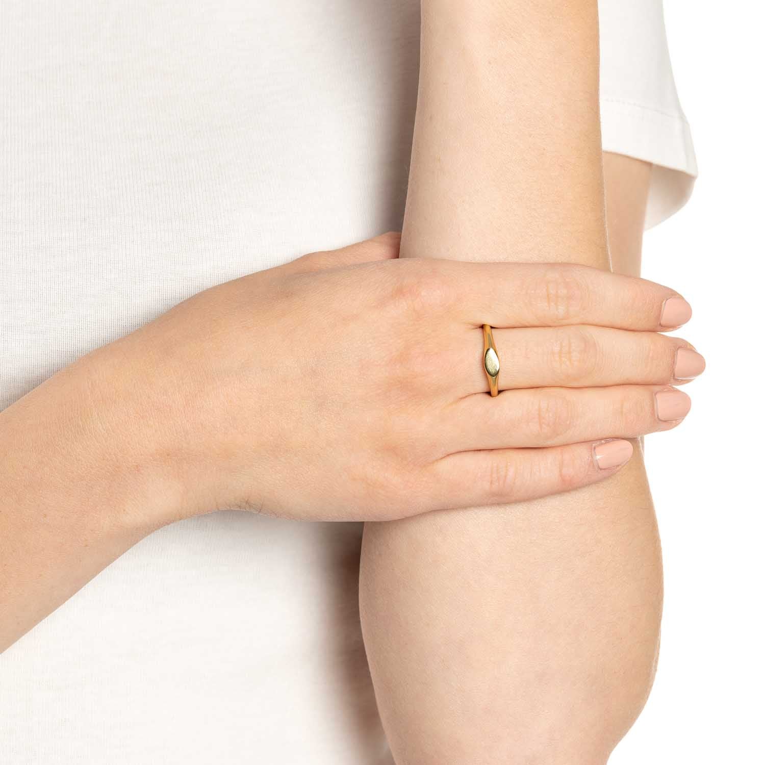Frau traegt goldenen Ring LOVIS 17 CIAO am Finger, weisse Kleidung