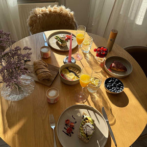 Sektgläser rosé auf gedecktem Frühstückstisch mit Gebäck und Obst