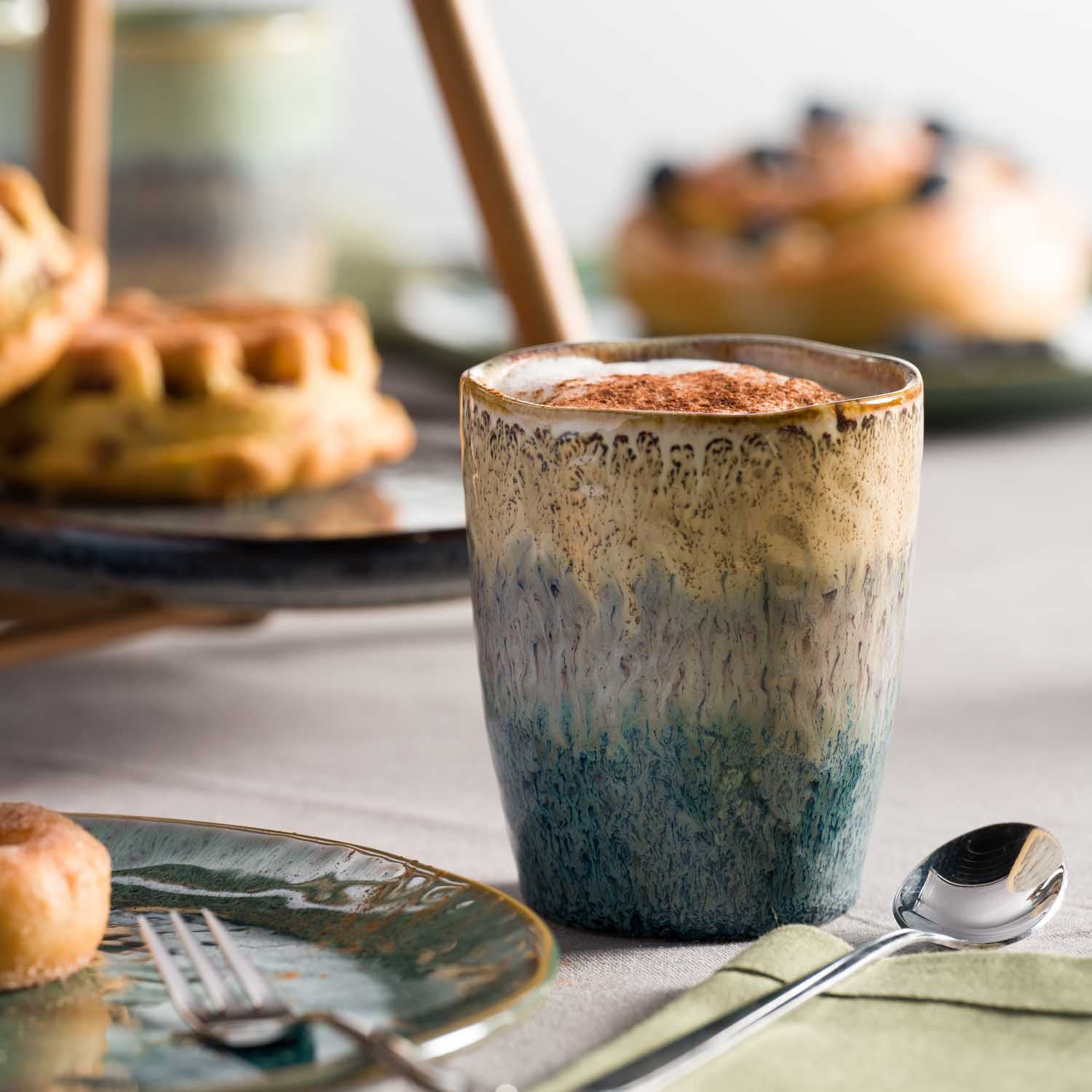 Becher MATERA mit Farbverlauf auf gedecktem Tisch mit Gebäck