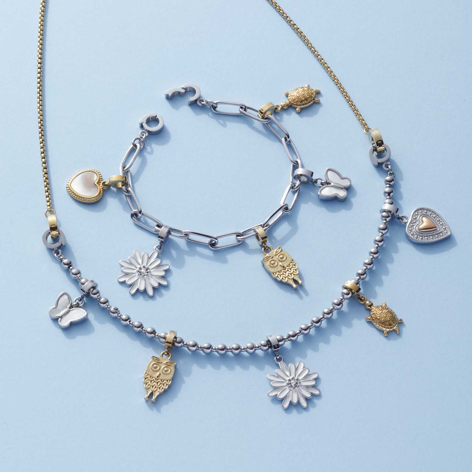 Anhänger MORA Clip & Mix in Gold und Silber auf hellblauem Hintergrund