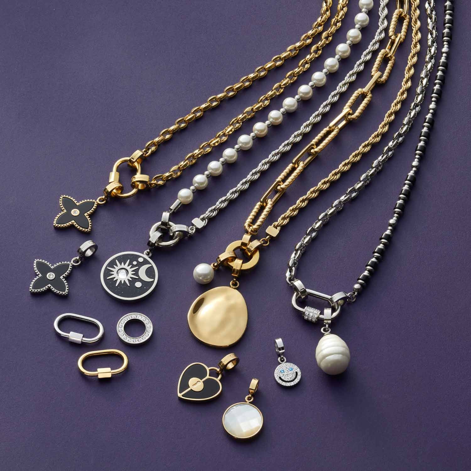 Anhänger COCO gold Clip & Mix mit Ketten und Ringen auf violettem Hintergrund