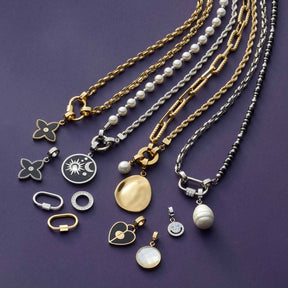 Anhänger COCO gold Clip & Mix mit Ketten und Ringen auf violettem Hintergrund