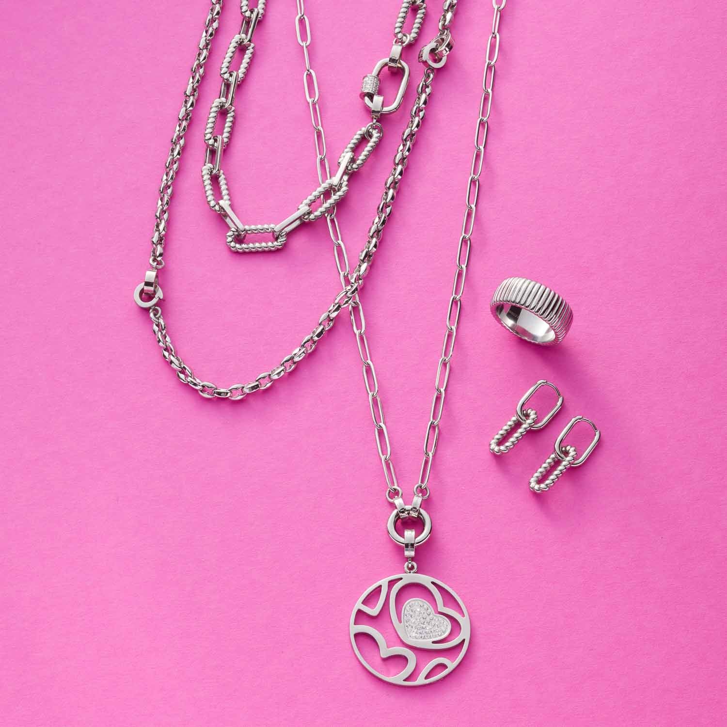 Halskette ROMEA mit Herzanhänger, Ring und Ohrringe auf rosa Hintergrund