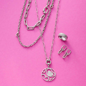 Halskette ROMEA mit Herzanhänger, Ring und Ohrringe auf rosa Hintergrund