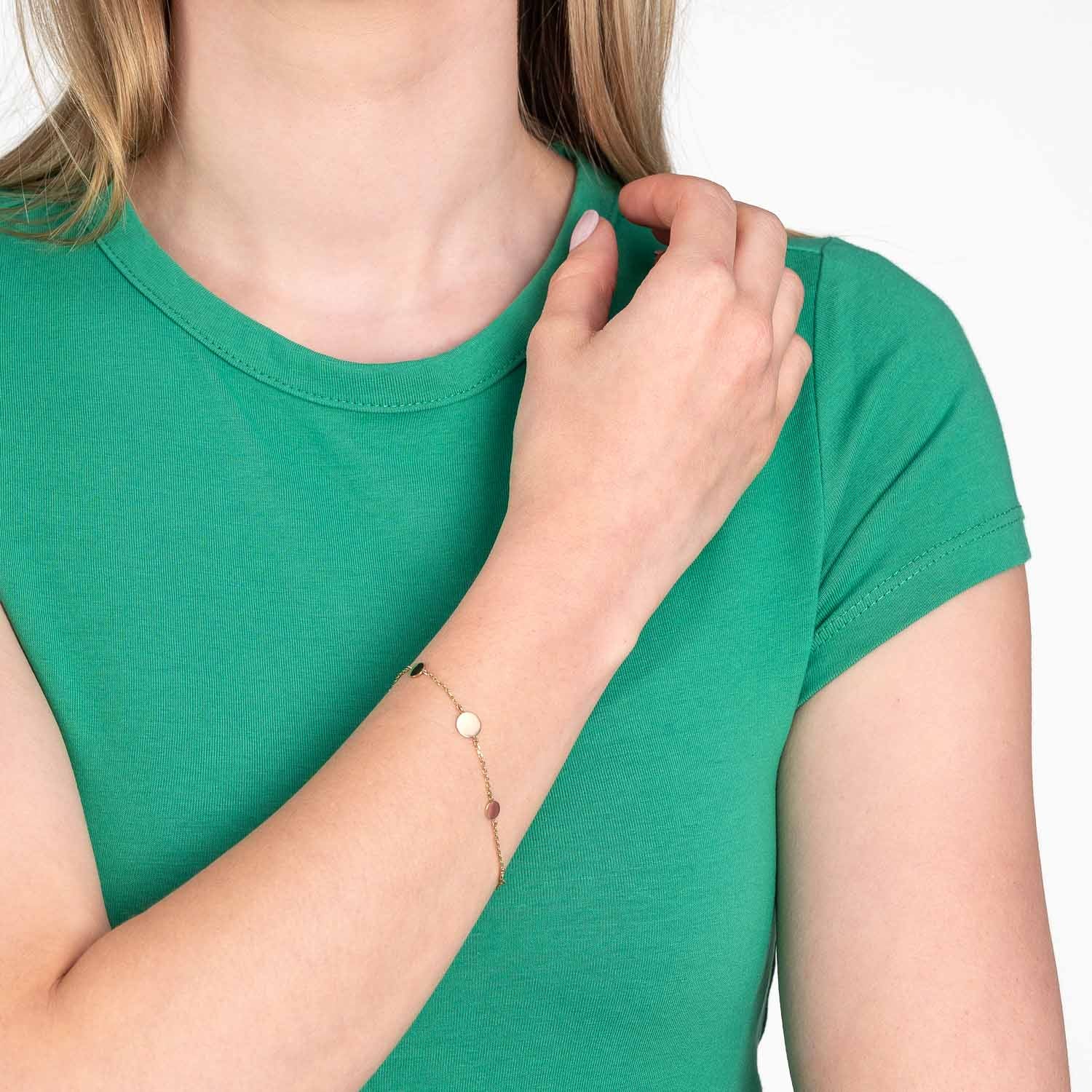 Frau traegt Armband MILLA gold am Handgelenk, gruenes T-Shirt