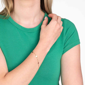 Frau traegt Armband MILLA gold am Handgelenk, gruenes T-Shirt