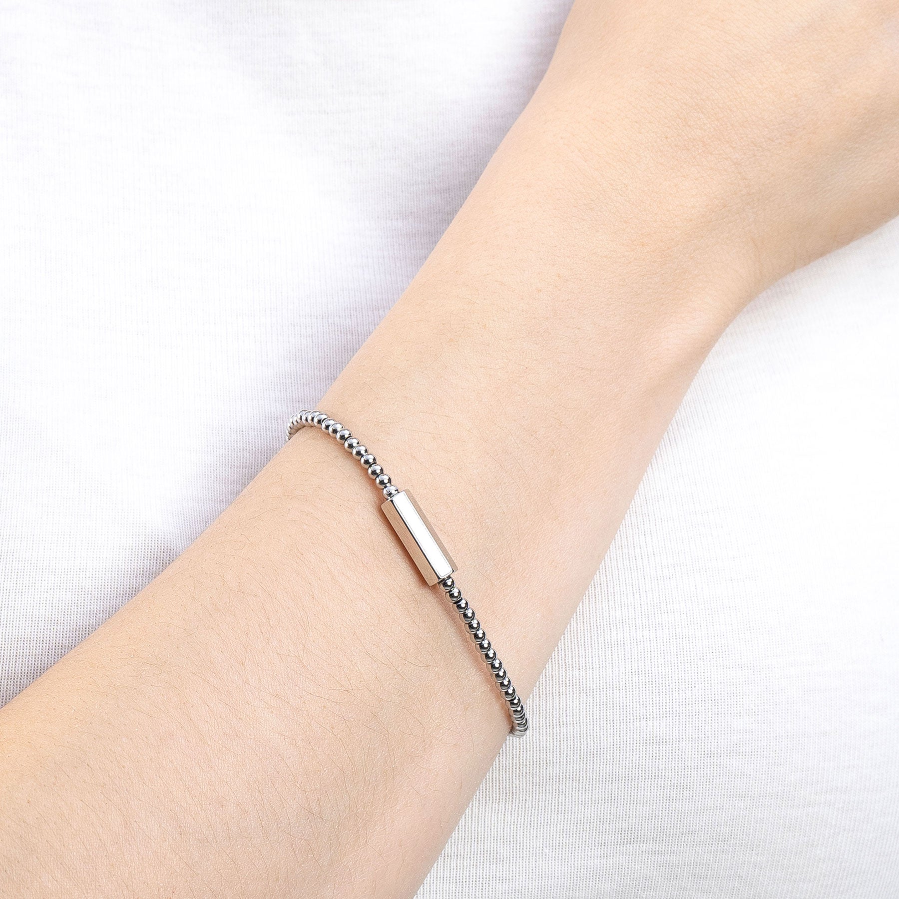 Armband PILEA gold an Frauenhand getragen, Nahaufnahme Handgelenk