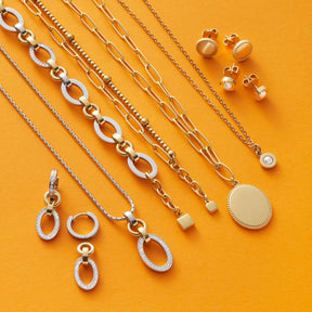 Schmuckkollektion der Serie LENA auf gelbem Hintergrund, Ketten, Armbänder, Ohrringe und Anhänger aus Edelstahl