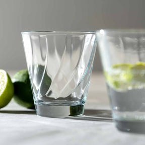 Trinkglas TWIST 215 ml mit Limettenscheiben auf weißer Oberfläche