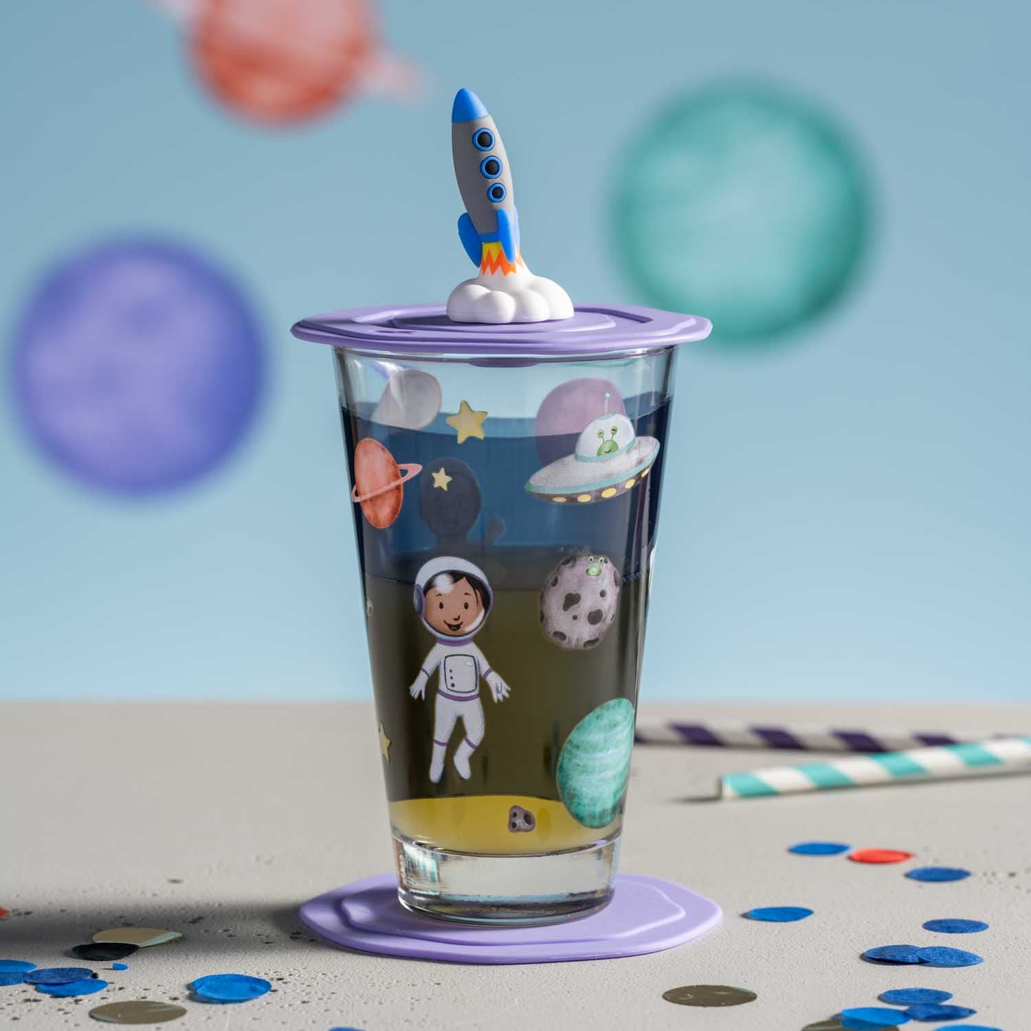 Trinkset BAMBINI AVVENTURA mit Weltall-Motiven, Rakete als Deckelgriff, auf Tisch mit Konfetti