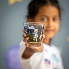 Kind hält Glas mit Weltall-Motiv in die Kamera