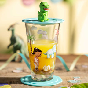 Trinkset BAMBINI AVVENTURA mit Dino-Deckel auf Holztisch, Glas mit buntem Motiv gefuellt