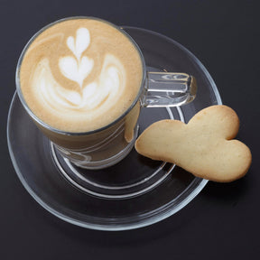 Glastasse SENSO mit Kaffee, Latte-Art-Dekoration und Keksen auf Untertasse