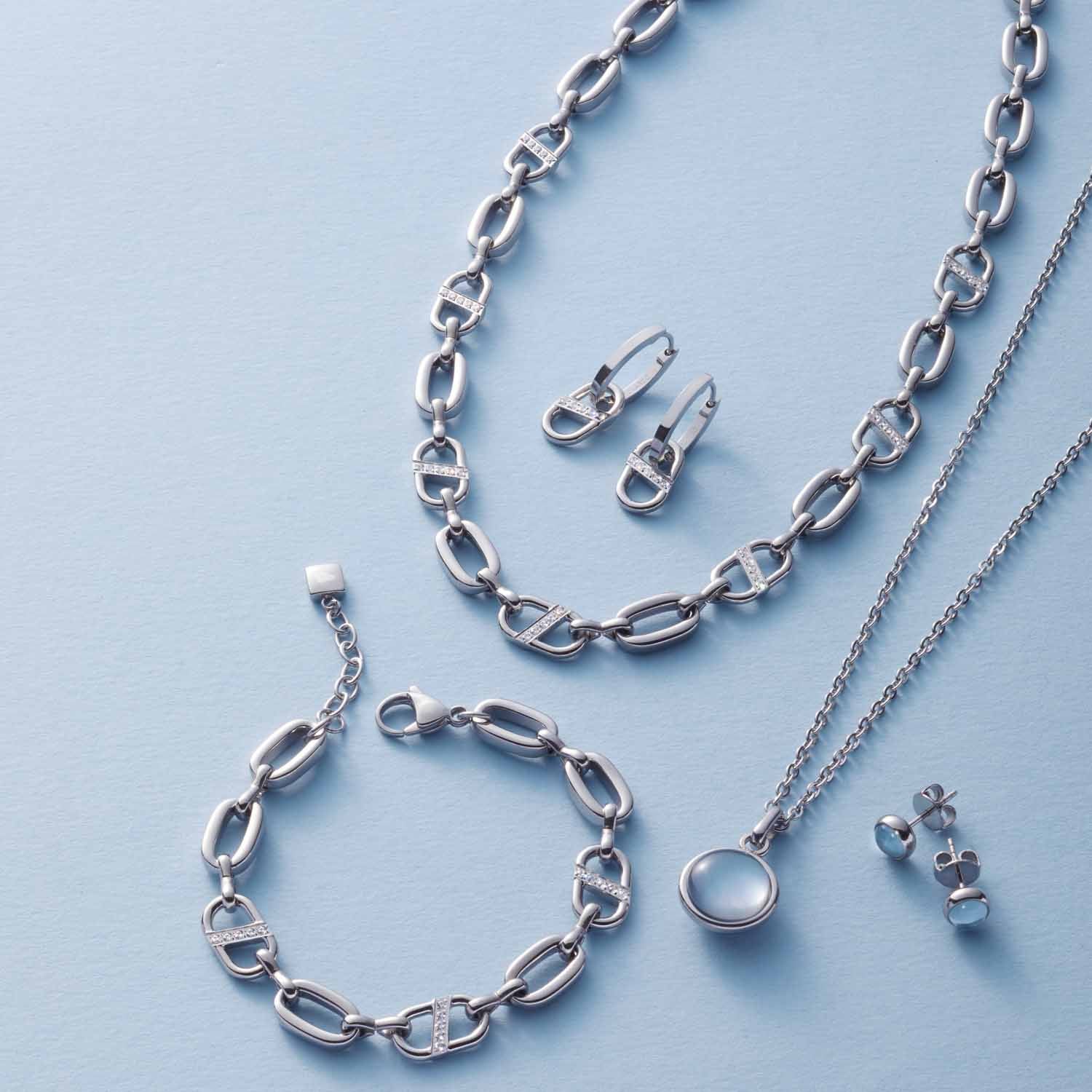 Silberne Schmuckkollektion NAREA mit Halsketten, Armbändern und Ohrringen auf hellem Hintergrund