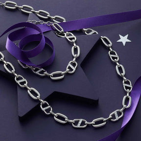 Armband NAREA silber mit Kettengliedern, lila Seidenband und Dekoelementen auf violettem Untergrund