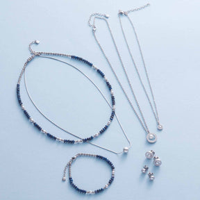 Halskette ANJANA mit Glasperlen, Armband und Kettenanhänger auf hellem Untergrund