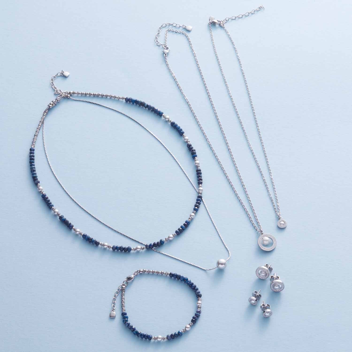 ANJANA Armband und Halsketten aus Edelstahl, Sodalith und Muscheln auf weißem Hintergrund