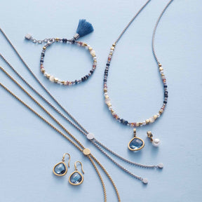 Armband BABSI mit Glasperlen, Ohrringe und Halsketten in Blautönen auf hellblauem Hintergrund