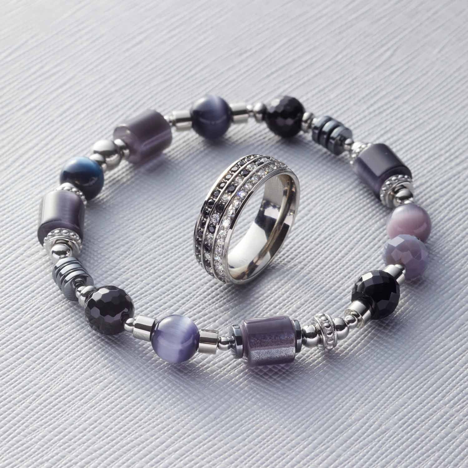 Ring ATURA 20 mit Glasperlen-Armband auf grauem Untergrund