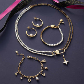 Schmuckkollektion mit Halskette LUCINDA, Ohrringen, Armbändern und Perlenketten auf grauem Hintergrund mit farbigen Bändern