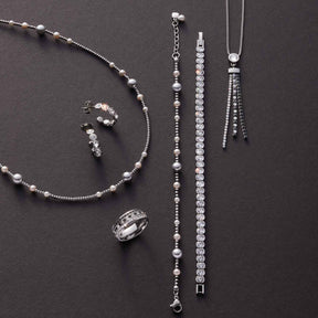 Schmuckset ELSANA mit Halskette, Armband, Ring und Ohrringen in Silber auf grauem Hintergrund