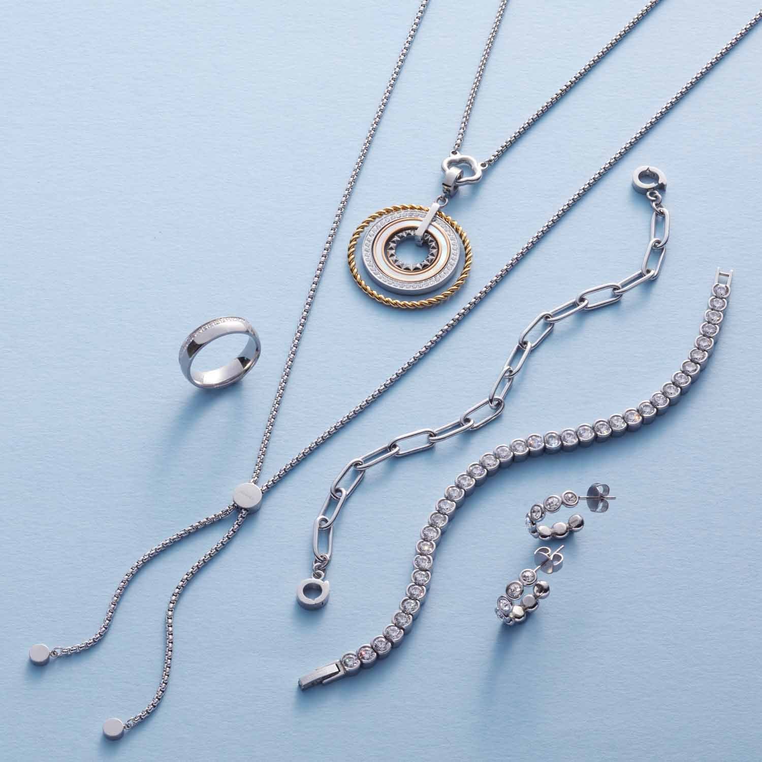 Silberner Schmuck mit Ohrsteckern CREMONA, Ketten und Armbändern auf hellblauem Untergrund