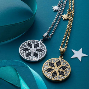 Zwei Halsketten BIELLA mit Zirkonium-Anhängern in Silber und Gold auf türkisblauem Hintergrund mit Bändern und Sternen