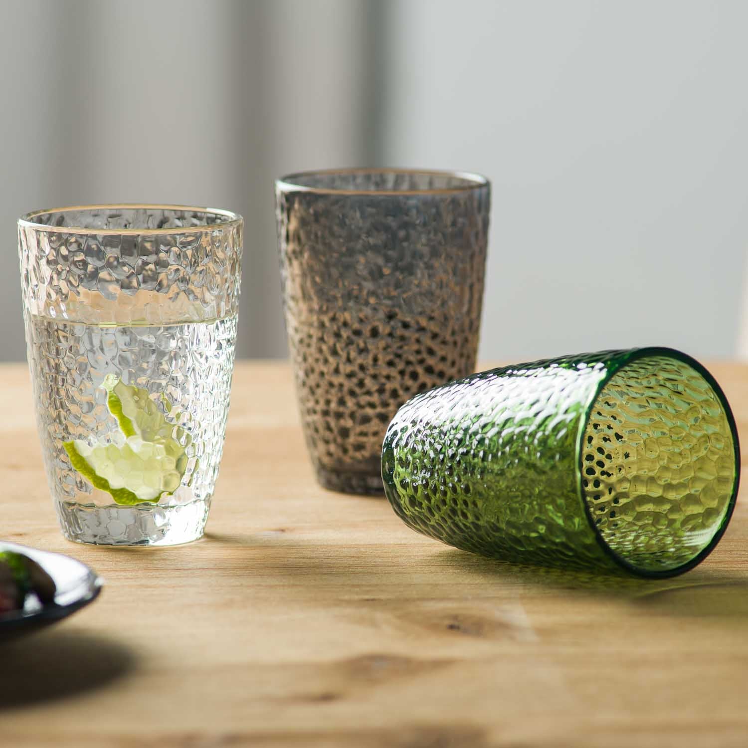 Trinkgläser MATERA mit Strukturoberfläche, eines mit Limettenscheibe gefüllt, auf Holztisch