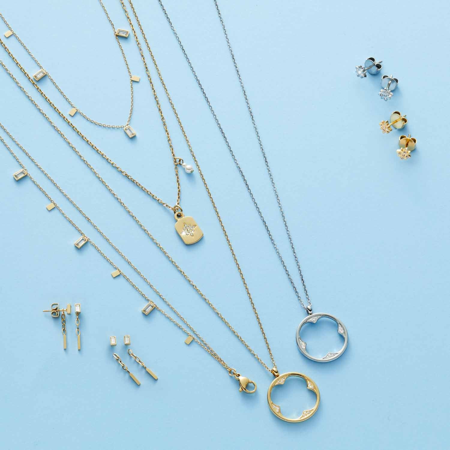 Halskette AMARILA gold mit Glas-Anhängern und passenden Ohrsteckern auf blauem Hintergrund