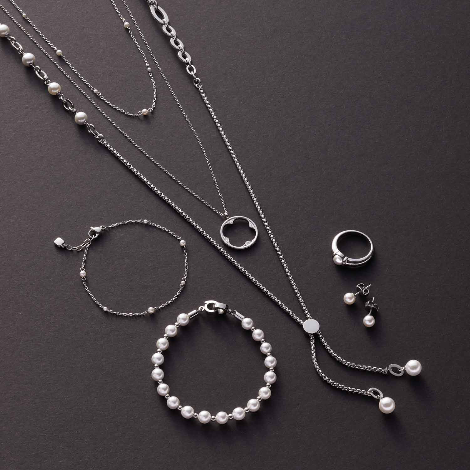 Silberne Schmuckkollektion CAMPAGNOLA mit Halsketten, Armbändern und Ohrringen auf grauem Untergrund