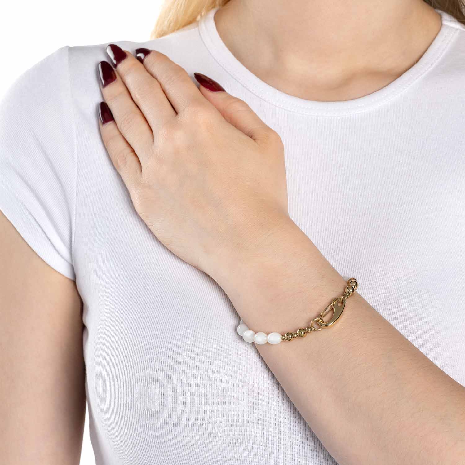 Frau trägt Armband PATSY gold mit Muscheln am Handgelenk