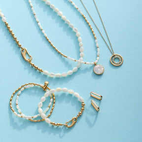 Halskette WELDA, Armbänder und Ohrringe aus Muscheln und Perlmutt auf blauem Hintergrund