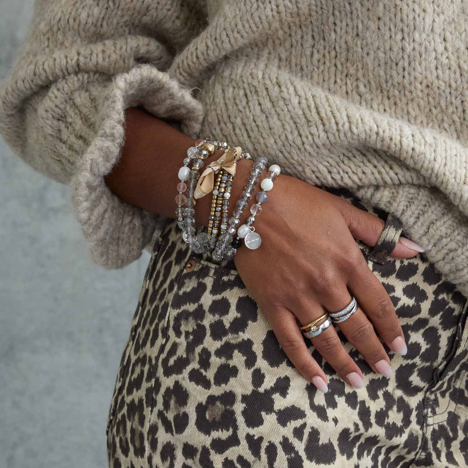 Armband BERNADETTE gold an Hand mit Leoparden-Print-Stoff und beige Strickpullover