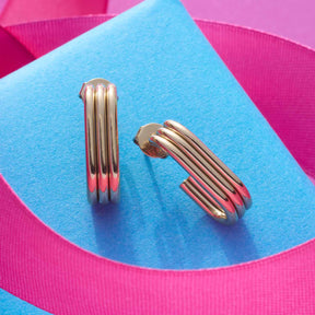 Ohrstecker ELISABETH gold auf blauem und pinkem Untergrund, Draufsicht