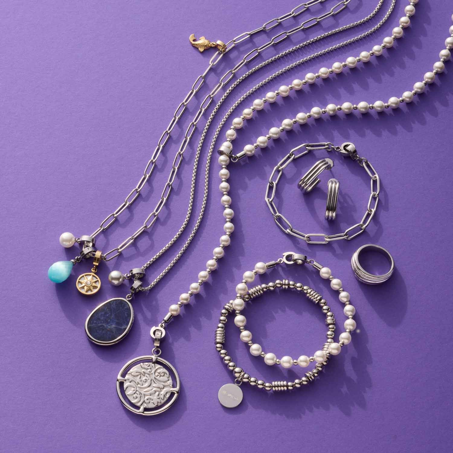 Schmuckkollektion mit Ketten, Armbändern und Ring ELISABETH 17 auf lila Hintergrund
